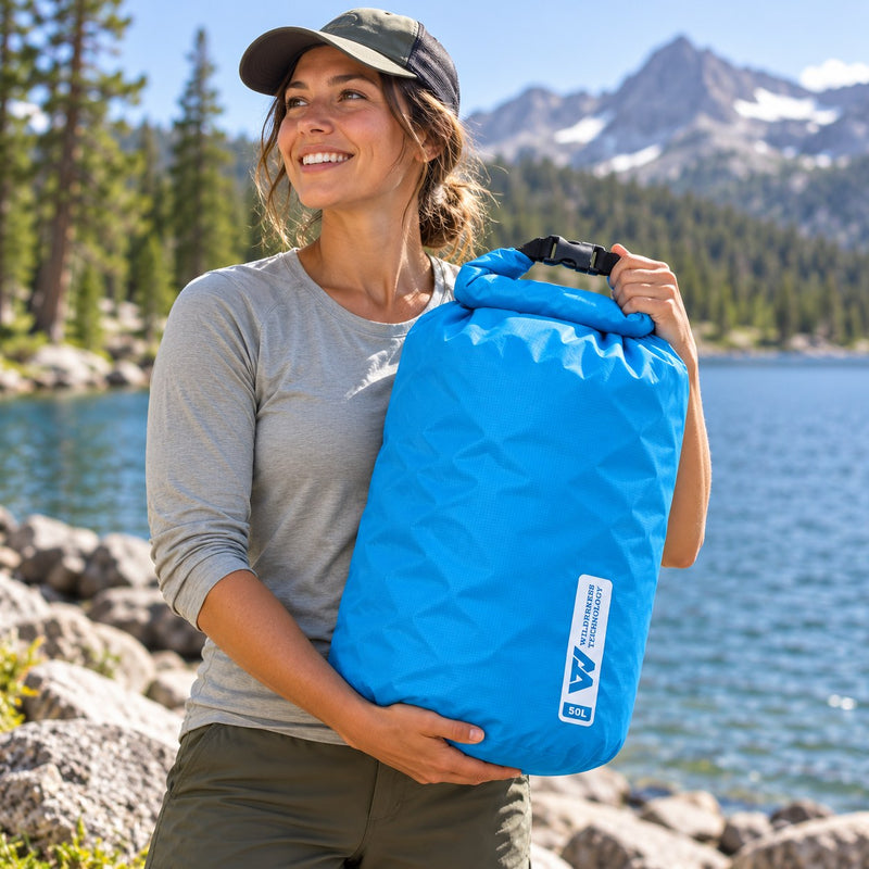 Load image into Gallery viewer, Wilderness Technology Ultralight Dry Bag 50L in Dark Teal, in use outdoors
